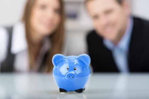 A couple looks at a piggy bank