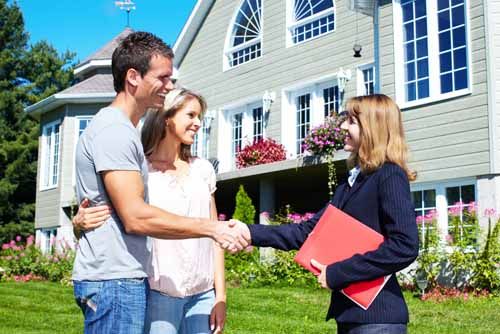 A public adjuster shakes hands with homeowners