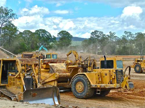 A heavy construction crew clears land for a project