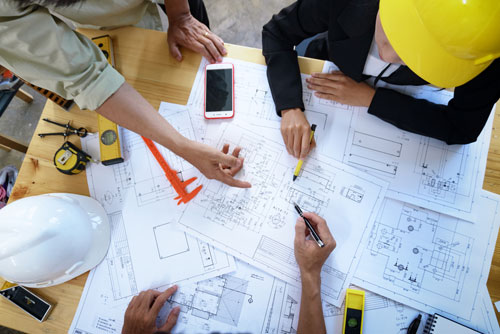 A general contractor checks blueprints