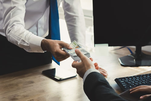 A New York check casher hands money to a client