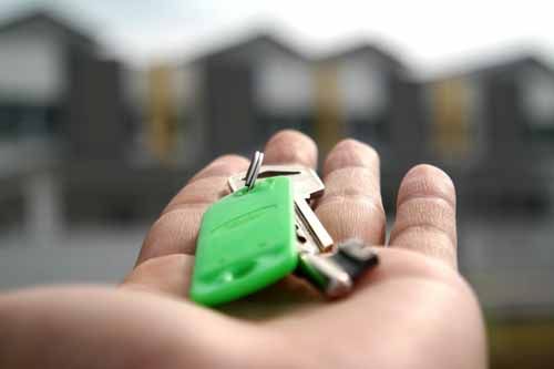 A realtor in District of Columbia shakes hands with clients in front of their new home