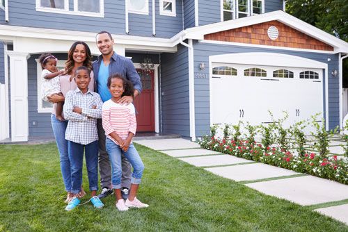 A family stands in front of their new home