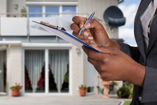 An appraiser looks at a house