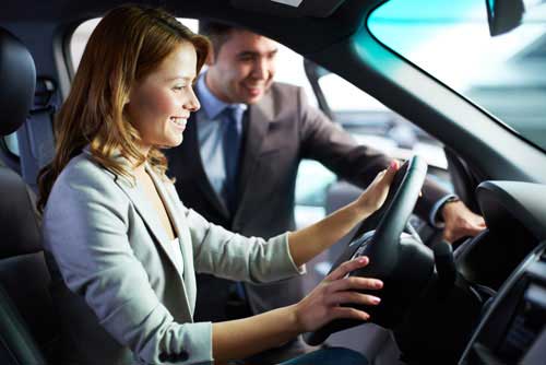 A car dealer shows a customer a car