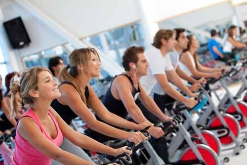 Members of a South Carolina Physical Fitness gym exercise on bicycles 