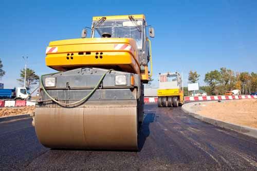 A road crew and contractor works on a highway