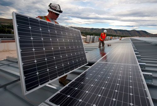 Workers install solar panels